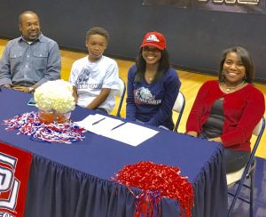 Raven Omar, second from right, signs with Samford as her family looks on.