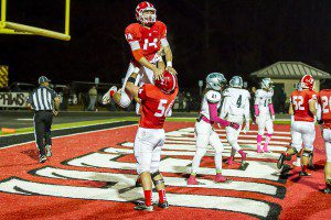 Sophomore offensive lineman Cameron Moore (56) lifts up junior quarterback Zac Thomas (14) after a Hewitt-Trussville touchdown on Oct. 30, 2014 against Clay-Chalkville.  file photo by Ron Burkett