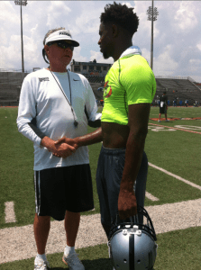 Former Hoover head football coach and current Colquitt County (GA) head coach, Rush Propst, gives Clay-Chalkville WR, T.J. Simmons, advice at the National Select 7-on-7 in Hoover. photo by Erik Harris 