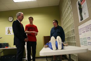 State Supt. Dr. Tommy Bice observes HTHS students as they work in the EMT class. Photo by Chris Yow