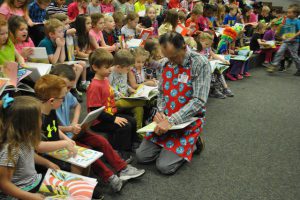 The Trussville Rotary Daybreak Club gave 140 kindergarten students at Paine Primary School a Dr. Seuss book. Shown, Rotarian John Patterson writes the kids names in their books. (photo submitted by Diane Poole)