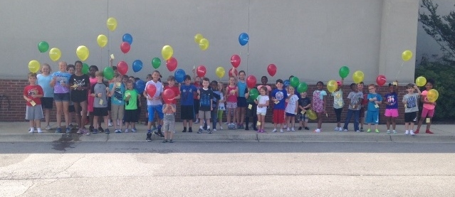 Summer campers release balloons to learn about geography 