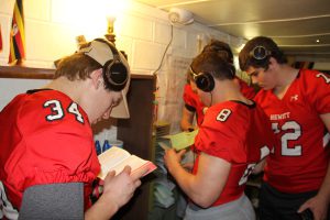 Hewitt-Trussville football team members examine a bookshelf with a Bible. Photo by Chris Yow